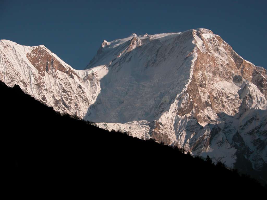 Manaslu 09 08 Manaslu From Bimtang I climbed the ridge behind Bimtang to get fantastic views of Manaslu's Northwest Face. The Pinnacle certainly looks lower than the summit from this vantage. The final leg of the normal ascent route looks a little steeper as it climbs up the left-hand ridge and passes the Pinnacle to reach the relatively flat but long, summit push.